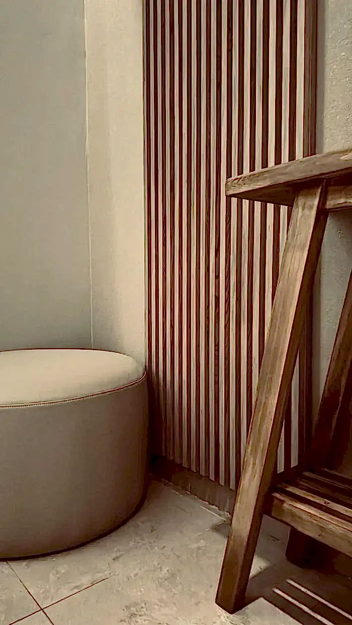 Panel de madera y puf de cuero blanco en cabina privada de Spa Belgrano